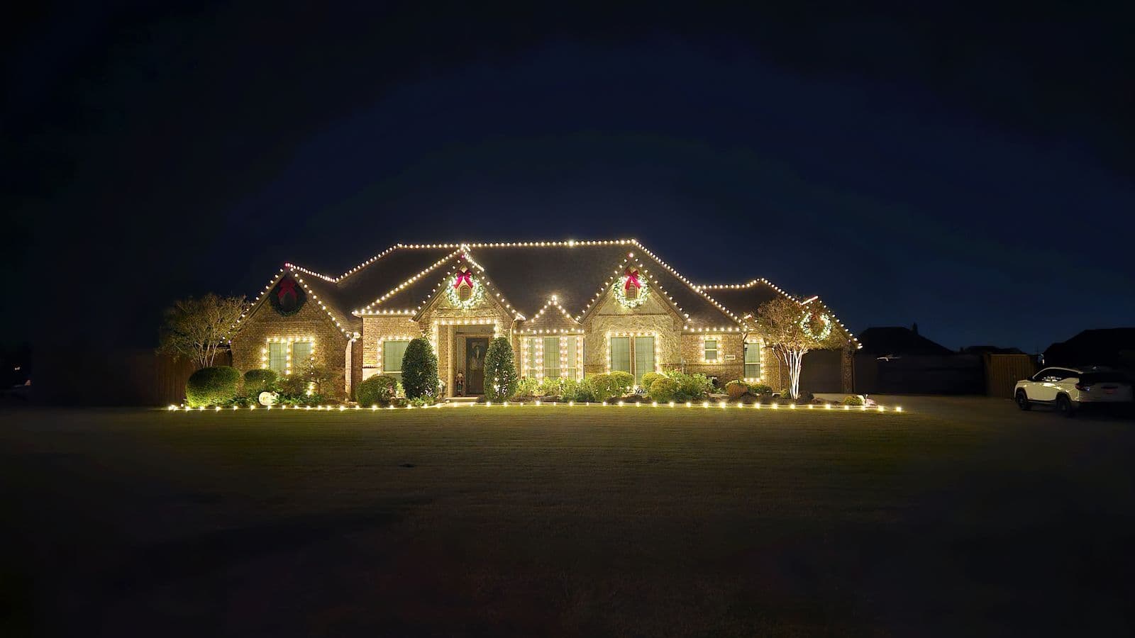 Brick home wrapped in a classic warm white Christmas light display